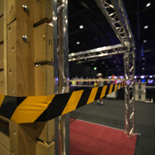 GRIP Eventbasics Absperrband schwarz-gelb gestreift | 500 m x 70 mm, nicht klebend | LDPE-Flatterband im praktischen Abrollkarton | Markierungsband für Gefahrenbereiche, Baustellenabsperrungen